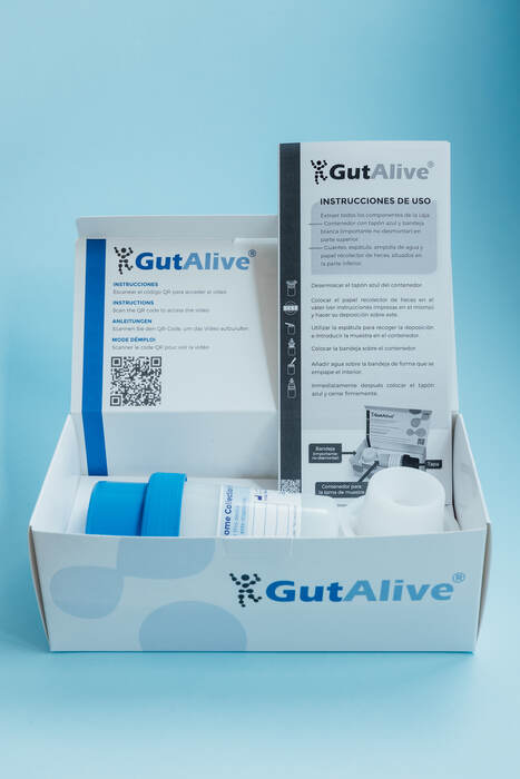 GutAlive kit open, showing the collection container, spatula, gloves and instructions